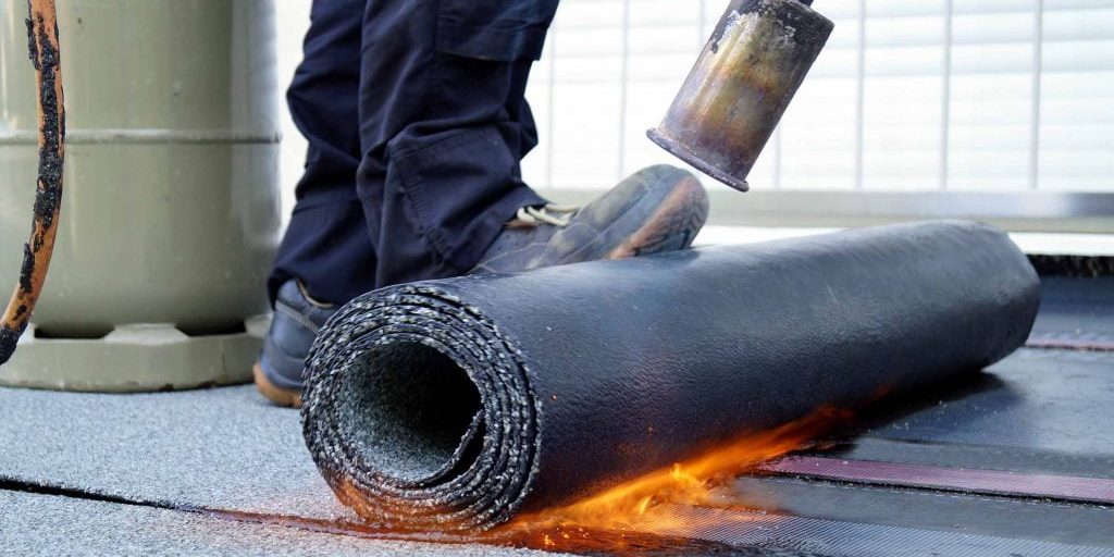 Flat Roof Installation With Propane Blowtorch During Constructio